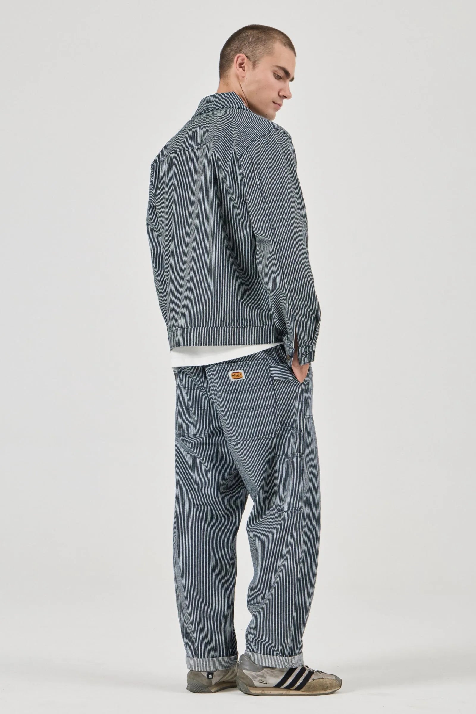 Person wearing a gray checkered jacket and pants on a white background
