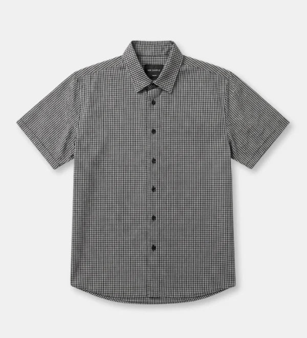 A short-sleeve button-up shirt with a small black and white micro-check pattern, displayed flat against a light gray background.