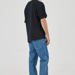 Person wearing a black t-shirt and blue jeans on a white background