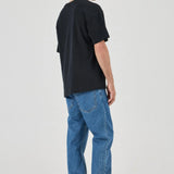 Person wearing a black t-shirt and blue jeans on a white background