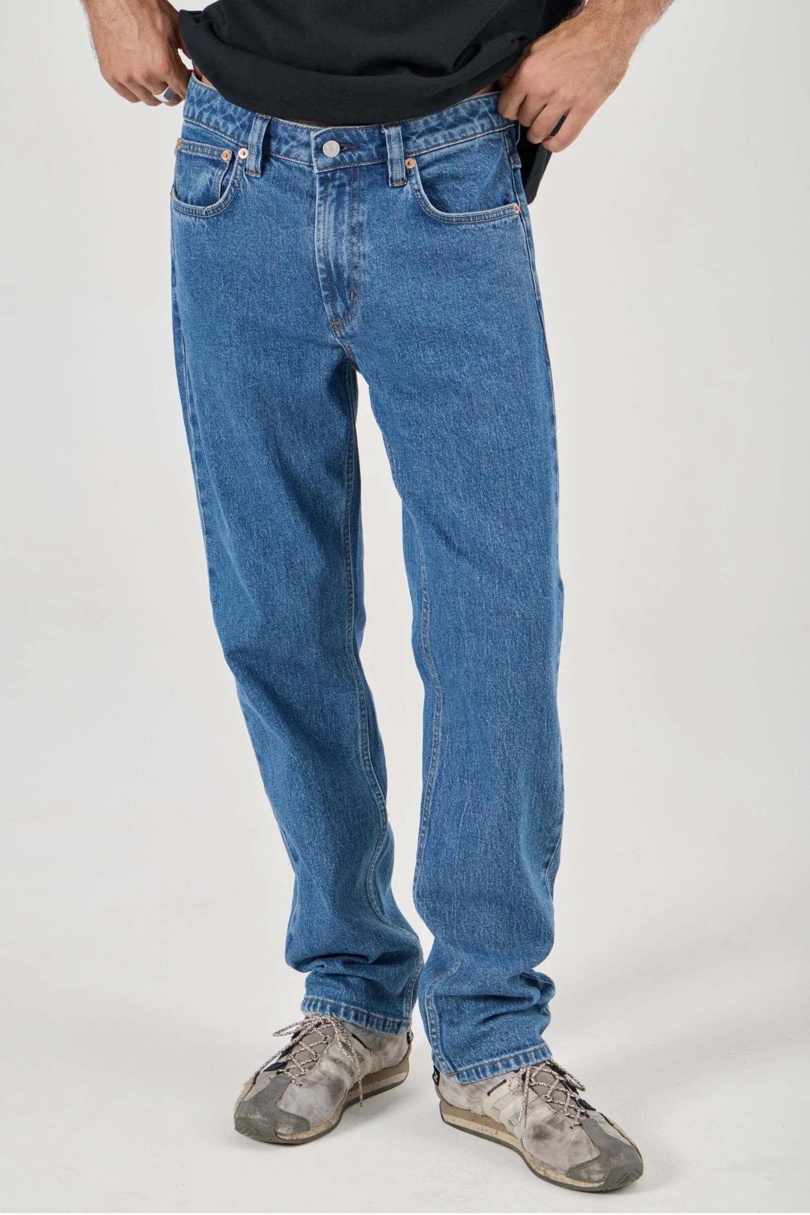 Person wearing blue jeans on a white background