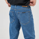Person wearing blue jeans and a black shirt on a white background