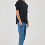 Man wearing a black t-shirt and blue jeans on a white background