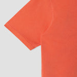 Close-up of an orange t-shirt on a light gray background