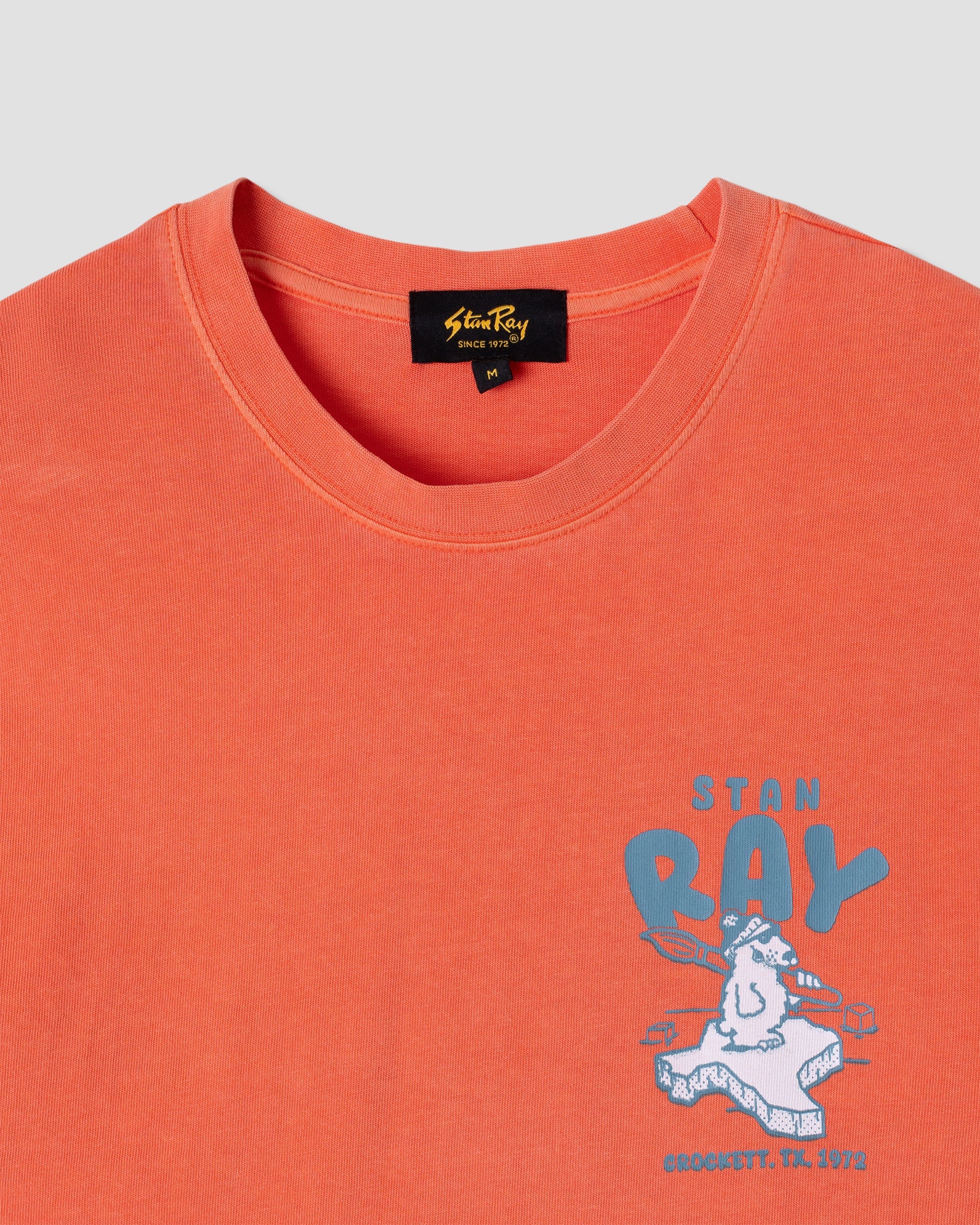 Orange t-shirt with 'Stan Ray' graphic design on a light gray background