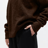 Brown sweater worn by a person on a white background