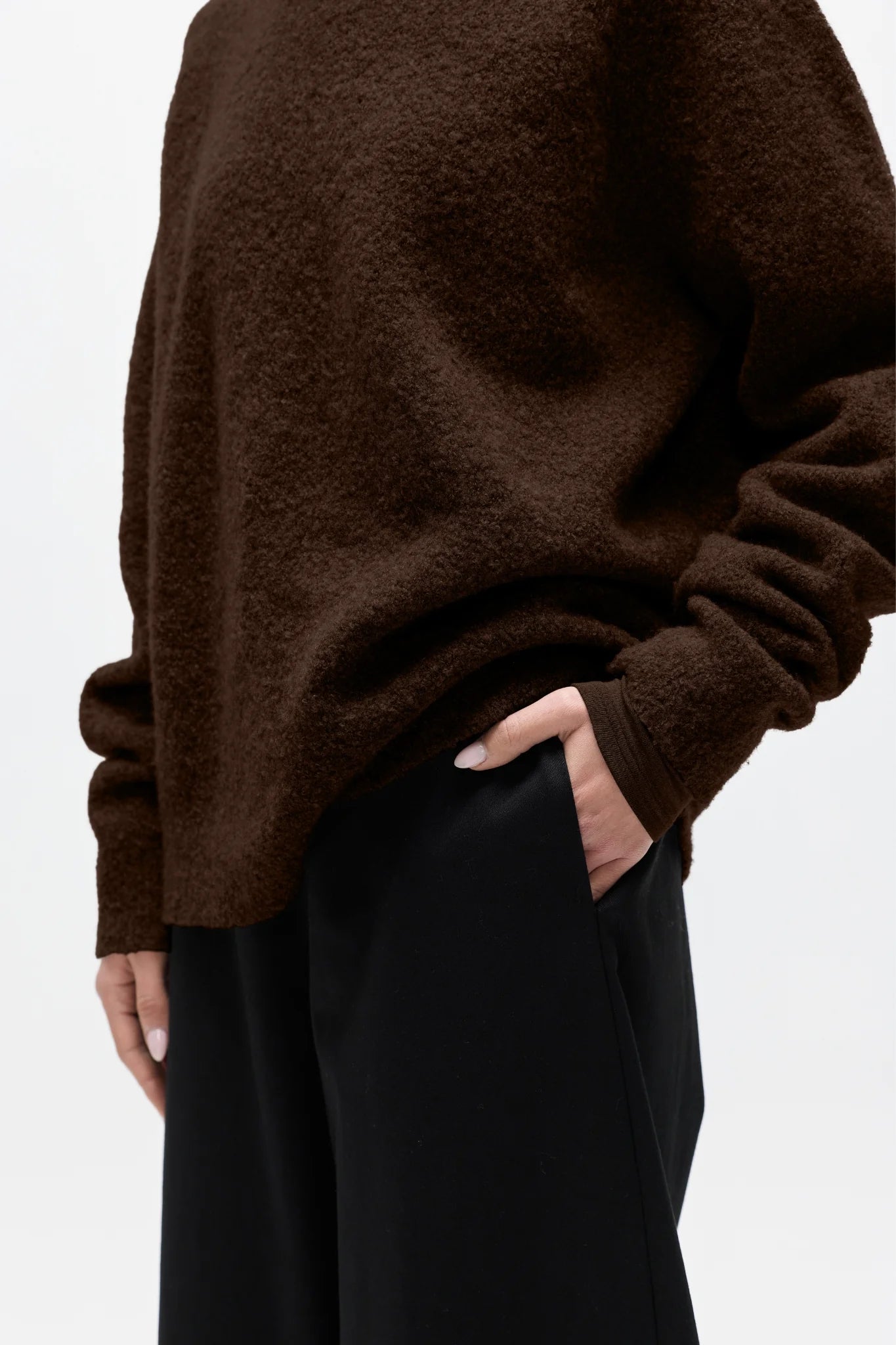 Brown sweater worn by a person on a white background