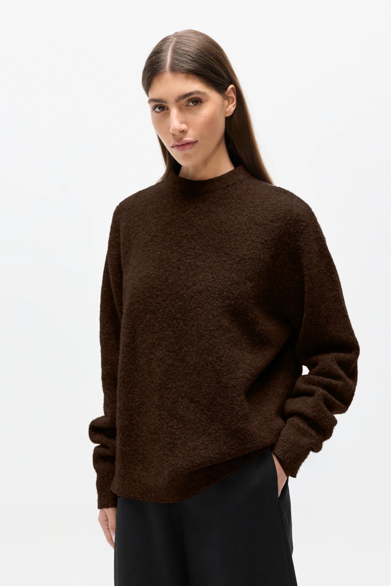 Woman wearing a brown sweater on a white background