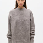Woman wearing a gray sweater on a white background