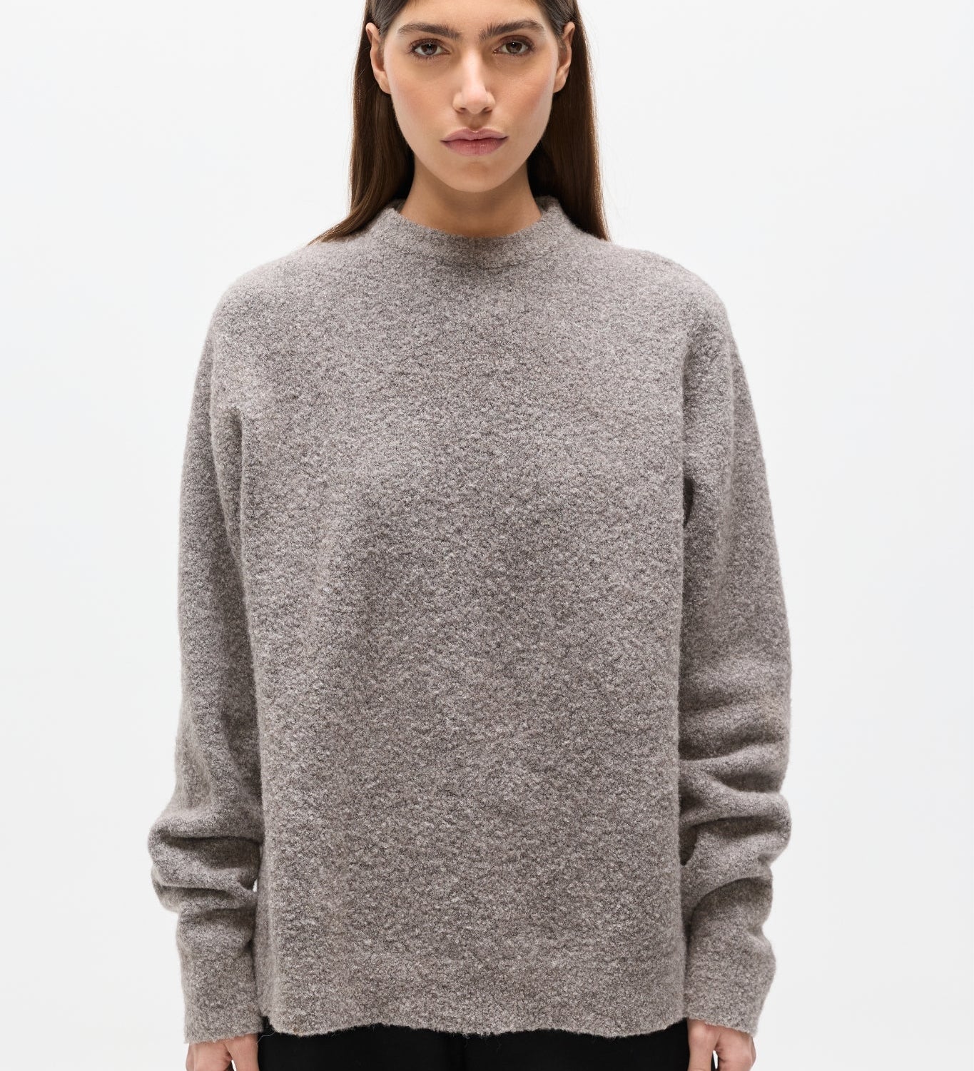 Woman wearing a gray sweater on a white background