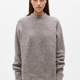 Woman wearing a gray sweater on a white background