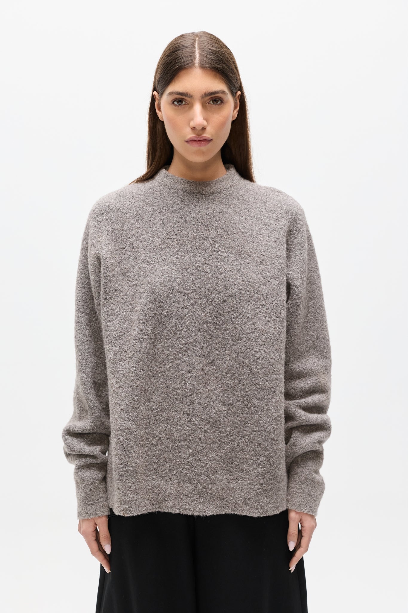 Woman wearing a gray sweater on a white background