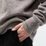 Person wearing a gray fleece jacket with a blurred background