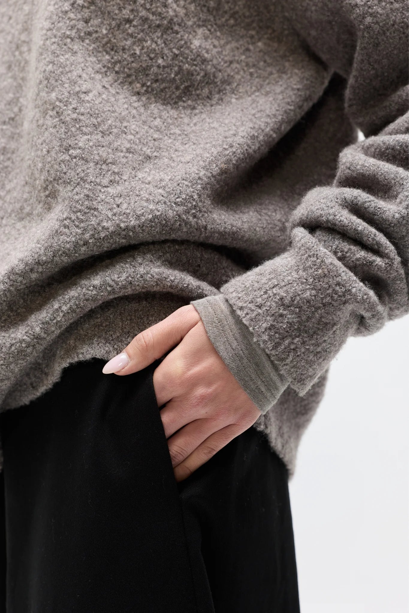 Person wearing a gray fleece jacket with a blurred background