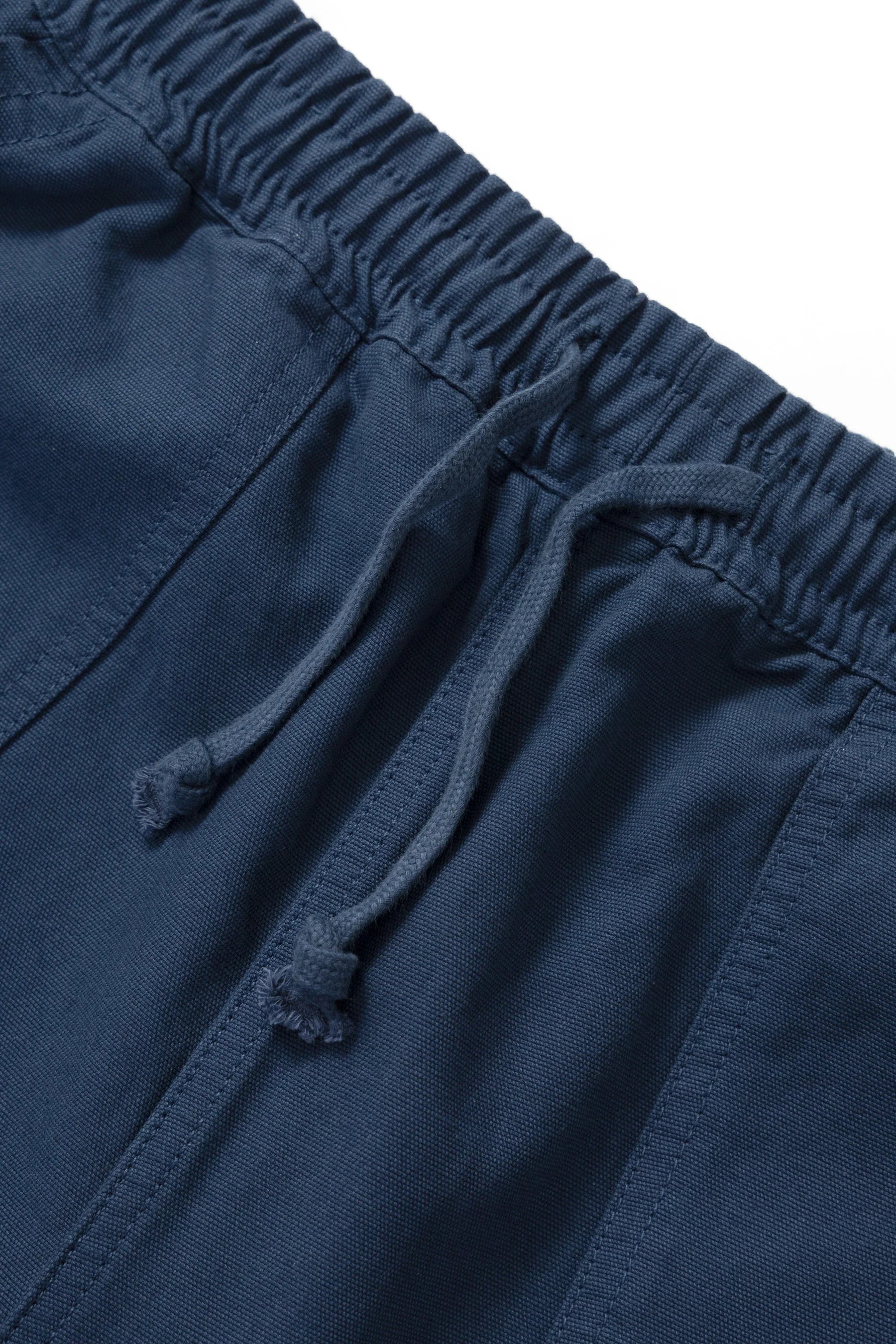 Close-up of blue shorts with drawstring on a white background