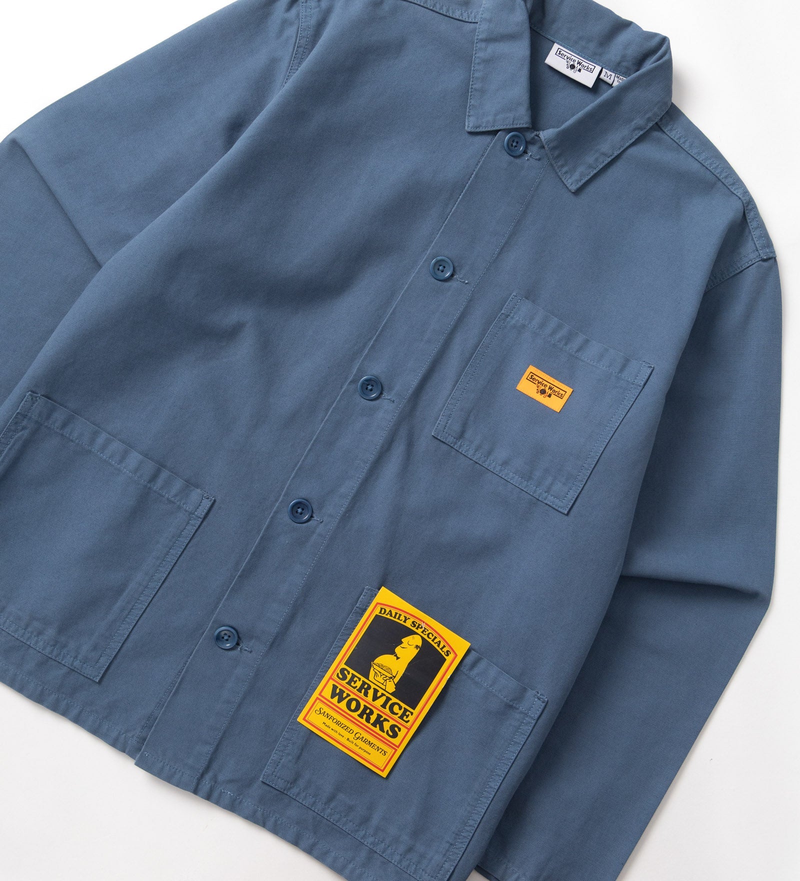 Blue shirt with a yellow label on a white background