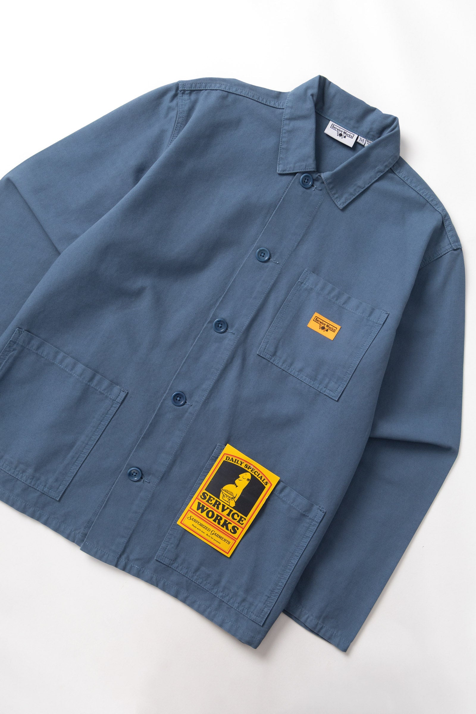 Blue shirt with a yellow label on a white background