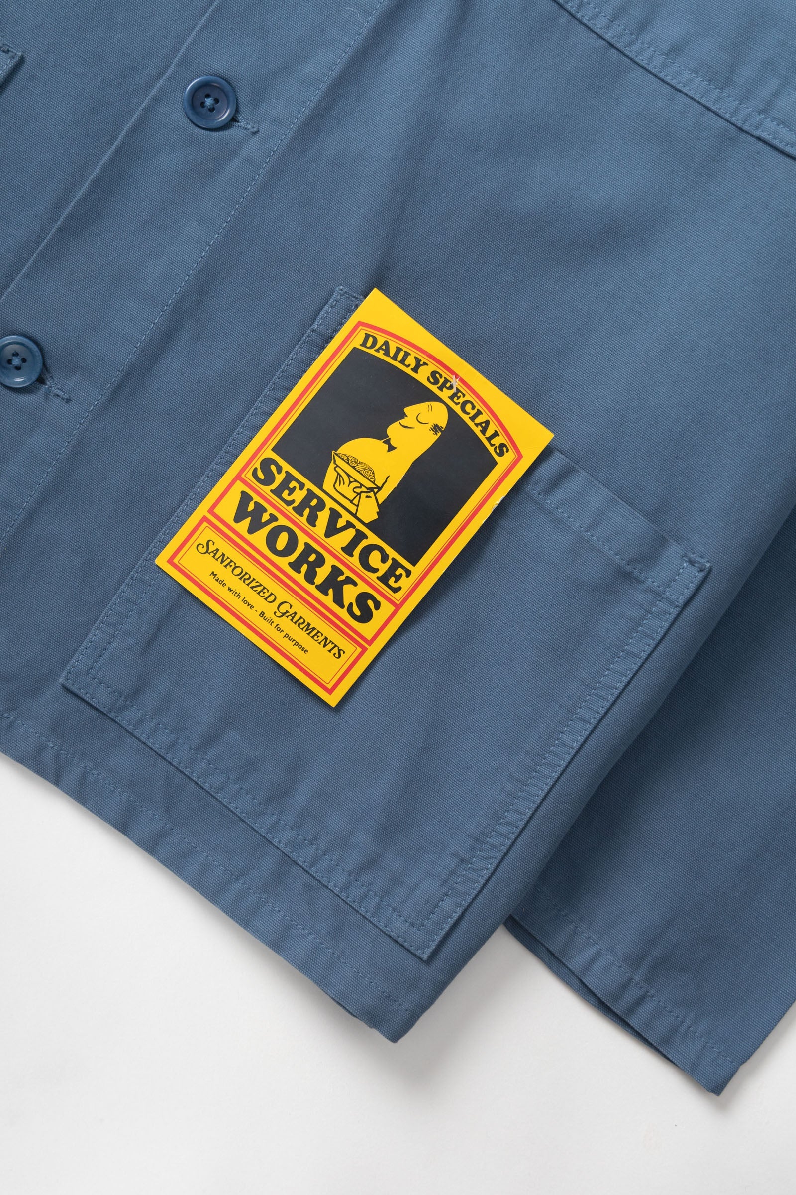 Blue shirt with a 'Service Works' patch on a white background