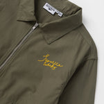 Green jacket with yellow embroidery and a brand label on a white background