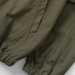 Close-up of olive green pants on a light gray background