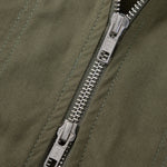 Close-up of a silver zipper on a green jacket