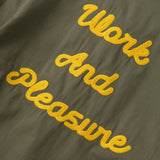 Green jacket with yellow text 'Work And Pleasure' on a dark background