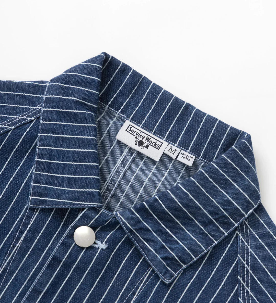 Close-up of a blue pinstripe shirt with a label on a white background