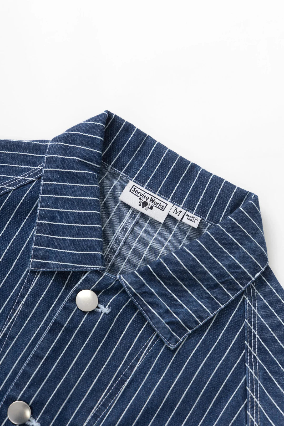 Close-up of a blue pinstripe shirt with a label on a white background