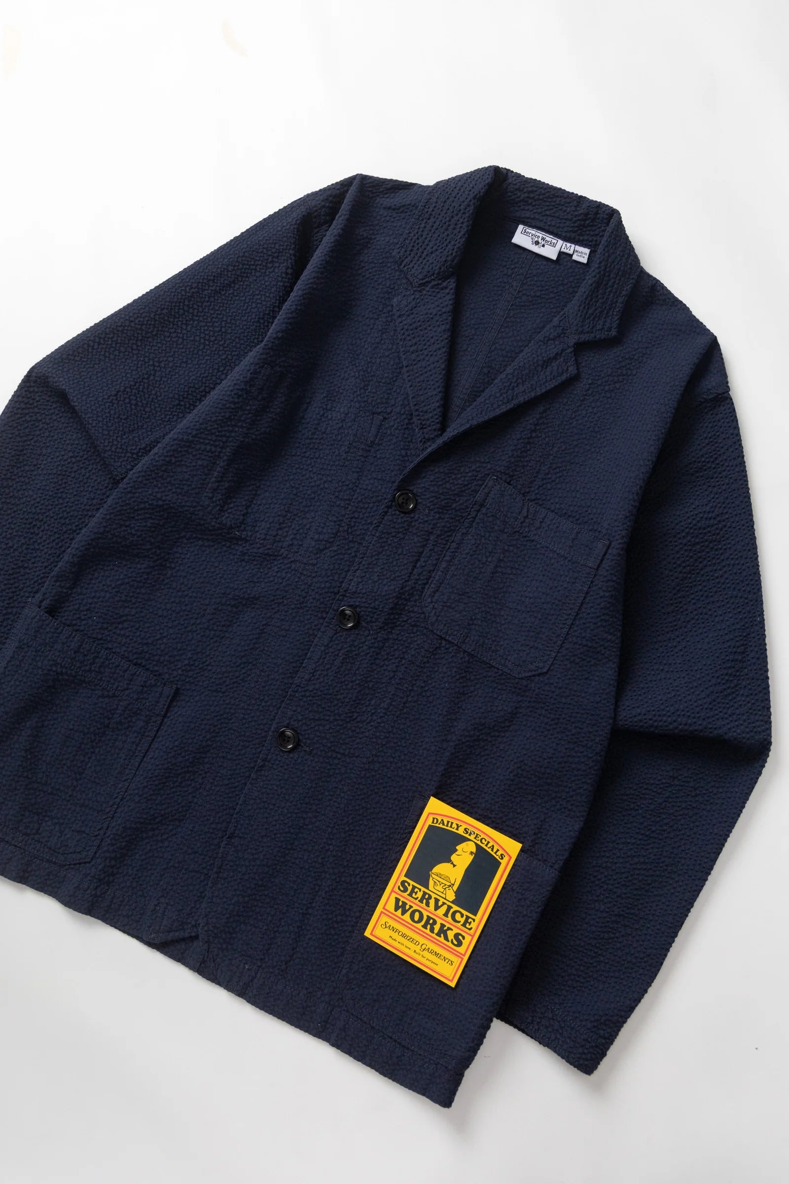 Navy jacket with a yellow label on a white background