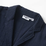 Navy textured jacket with a brand label on a white background