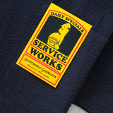 Navy blue fabric with a yellow 'Service Works' label on a white background