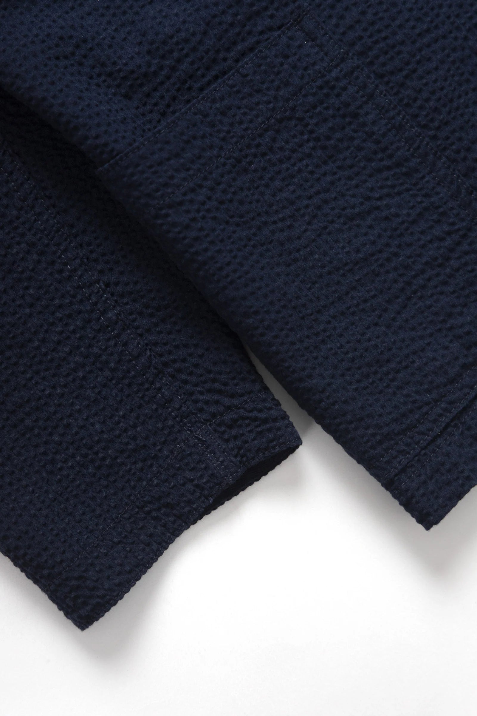 Close-up of a navy blue textured fabric on a white background