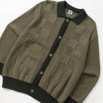 Green cardigan with black trim on a white background