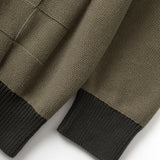 Close-up of a brown knitted sweater with black cuffs on a white background