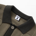 Close-up of a brown polo shirt with a black collar and button, featuring a brand label on a white background.