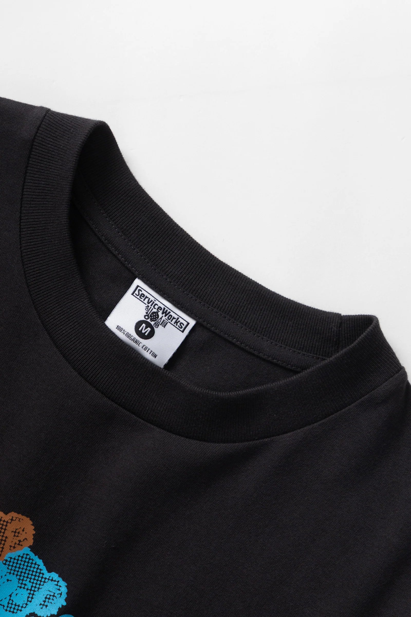 Black t-shirt with a small logo on a white background