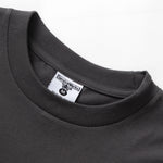 Close-up of a dark gray t-shirt with a brand label on a white background