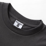 Close-up of a dark gray t-shirt with a brand label on a white background