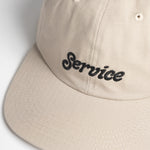 Beige cap with 'Service' embroidered on a light gray background
