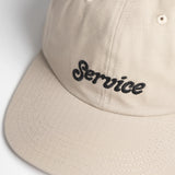 Beige cap with 'Service' embroidered on a light gray background