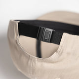 Beige cap with a black strap on a white background