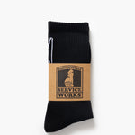 Black sock with a brown label on a white background