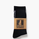 Black sock with a brown label on a white background