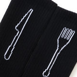 Black socks with white cutlery designs on a white background