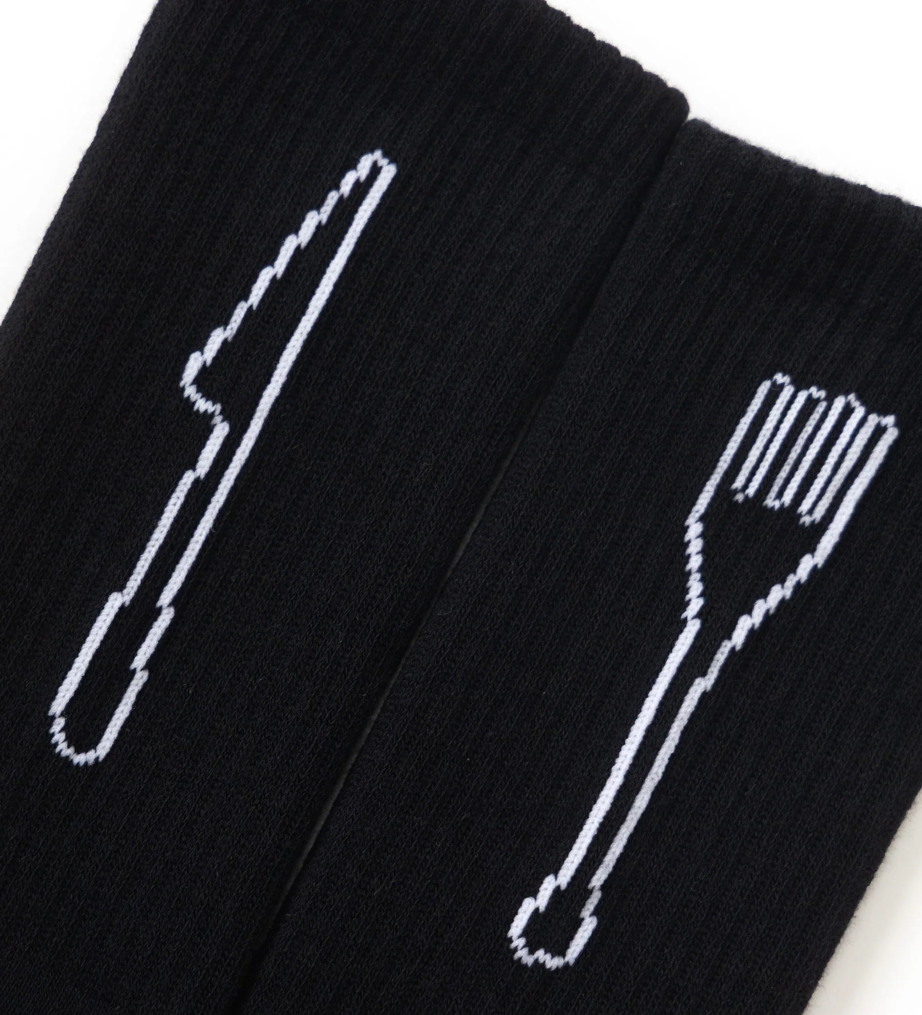 Black socks with white cutlery designs on a white background