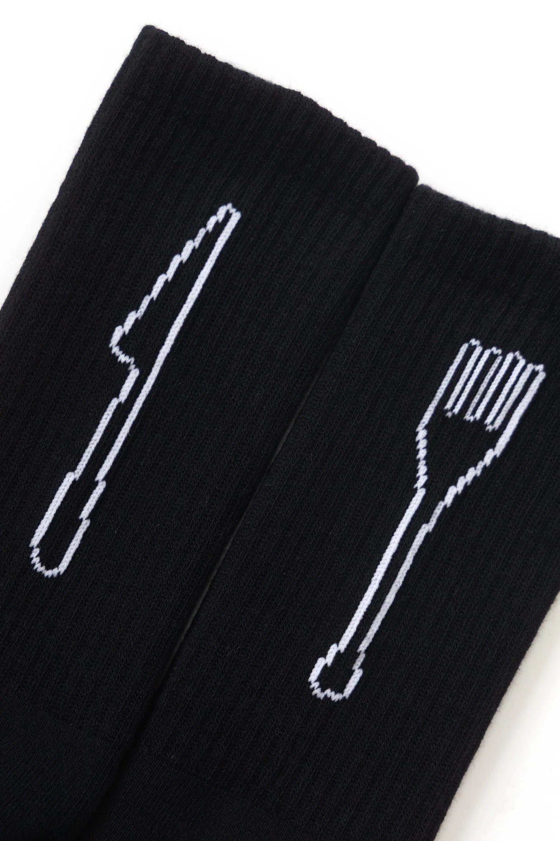 Black socks with white cutlery designs on a white background