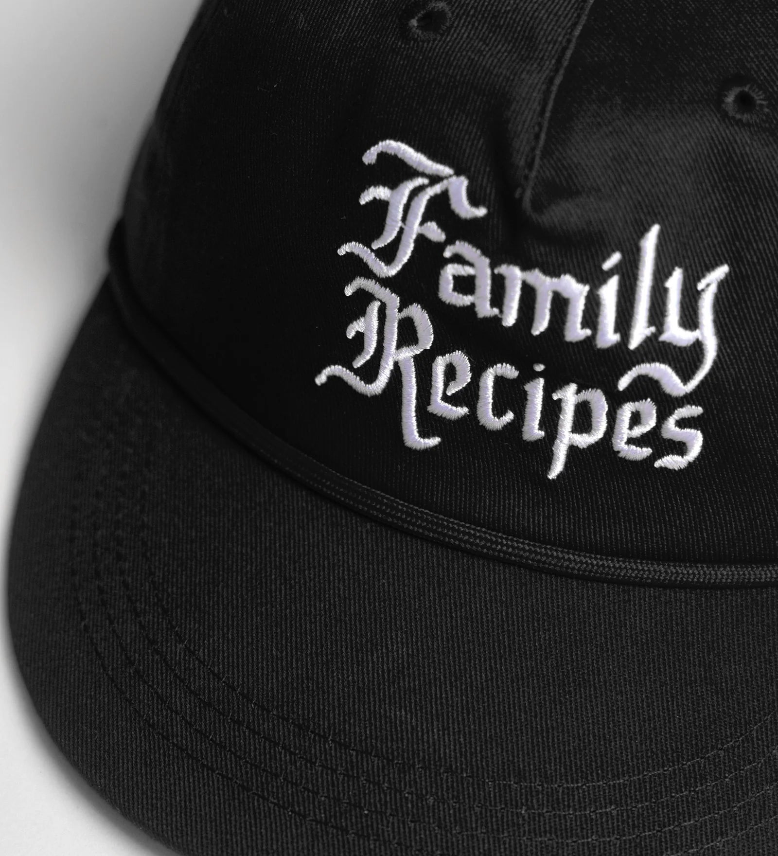 Black cap with 'Family Recipes' text on a light gray background