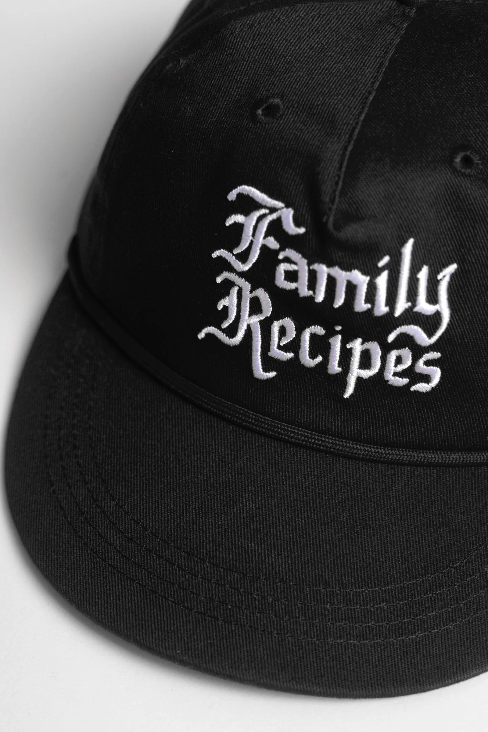 Black cap with 'Family Recipes' text on a light gray background