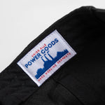 Close-up of a black garment with a visible label on a white background