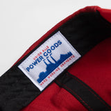 Close-up of a red jacket with a 'Power Goods' label on a white background